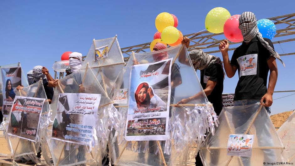 منطقة البُريج ، في قطاع غزة ، في الأراضي الفلسطينية - محتجون فلسطينيون يُحضِّرون بالونات وطائرات ورقية محملة بمواد قابلة للاشتعال، تُطَيَّر باتجاه إسرائيل على الحدود بين إسرائيل وغزة: البُريج وسط قطاع غزة بتاريخ 14 يونيو / حزيران 2018. (photo: Imago/ZUMA Press)