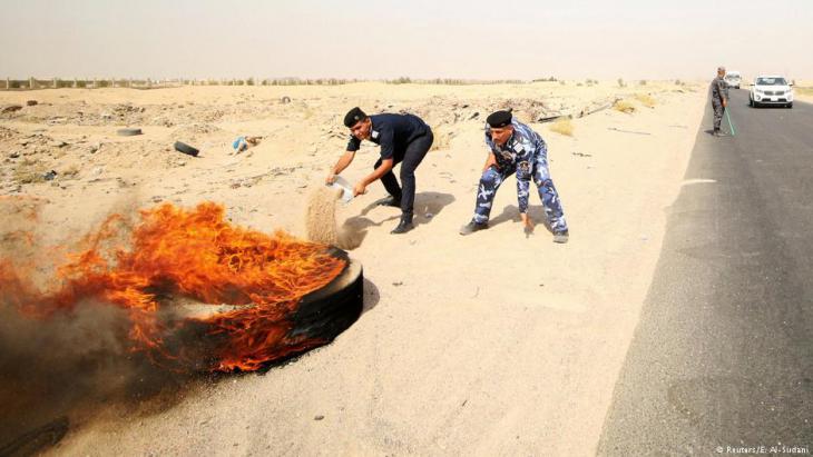 Iraqi security forces put out tyres set on fire by demonstrators near the Zubair oilfield in South Iraq (photo: Reuters/E. Al-Sudani)