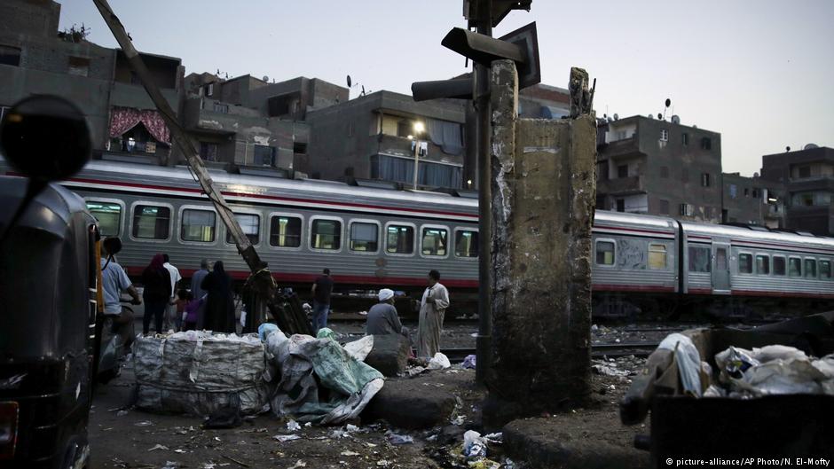 People wait for the train to pass in Shubra, Cairo, Egypt; October 2018 (photo: AP Photo/Nariman El-Mofty)