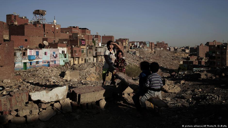 children play on a make shift see-saw made out of a tree trunk in slum area Ezbet Khairallah, Cairo; October 2018 (photo: AP Photo/Nariman El-Mofty)