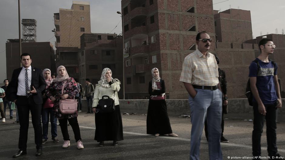 people wait for an early morning bus on the ring road, in Cairo; October 2018 (photo: AP Photo/Nariman El-Mofty)