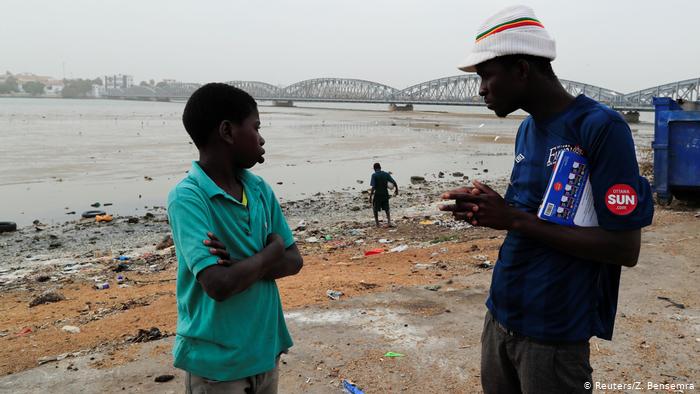 El Hadj Diallou (right), a former talibe, who became a medic at Maison De la Gare, talks with Ngorsek, 13 (photo: Zohra Bensemra)