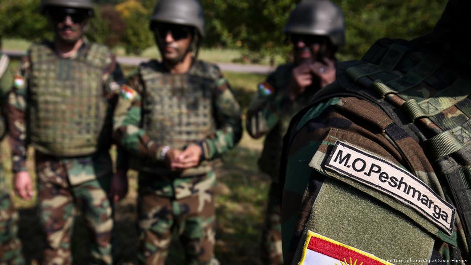 Kurdische Soldaten posieren im Oktober 2014 im Übungsdorf Bonnland auf dem Truppenübungsplatz der Infanterieschule Hammelburg (Bayern) mit einer kurdischen Flagge. 32 Peschmerga-Soldaten wurden in Unterfranken für den Kampf gegen die IS-Terrormiliz ausgebildet; Foto: David Ebener/dpa