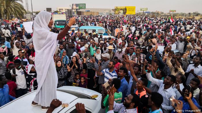 Alaa Salah stands on top of a car addressing protesters (photo: Getty Images/AFP)