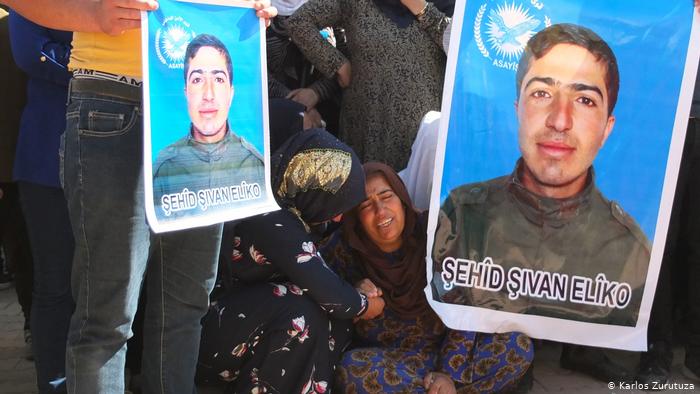 A woman mourns for her son at a funeral in Derik, Syria