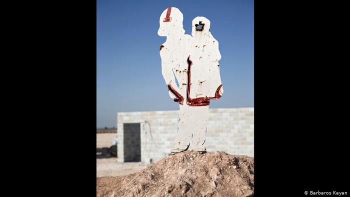 A metal figure shows the silhouette of a person with a child in their arms (photo: Barbaros Kayan)