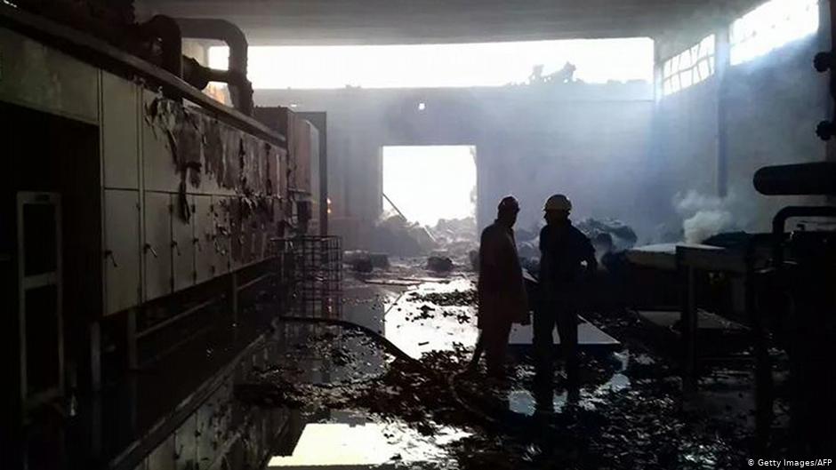 Firefighters stand in the burnt-out shell of a factory owned by Ahmadis in Jehlum, Pakistan. It was torched, along with an Ahmadi mosque, by an angry mob in November 2015 (photo: Getty Images/AFP)