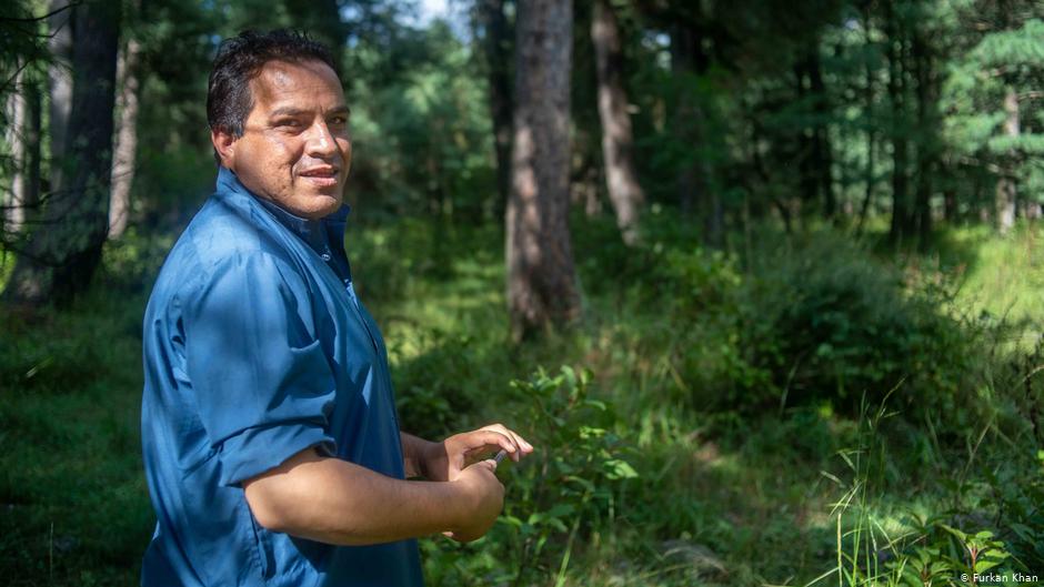 Mushtaq Pahalgami (39) steht vor einem Waldgebiet, das er pflegt; Foto: Furkan Khan