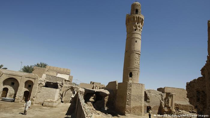 Minaret in front of old stone buildings