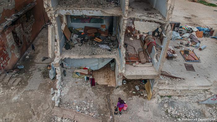 Mohannad Zayat shows a woman and child taking refuge in a destroyed shelter