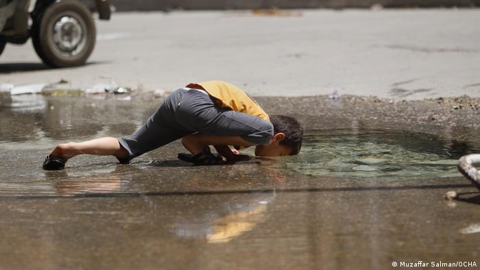 Muzaffar Salman captured a boy drinking from a destroyed pipe out of a bomb crater