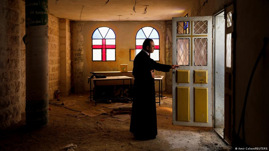 Father Simon Khoury looks out as he opens the door of a room under renovation at his church in Kafr Kana, in northern Israel, 15 March 2021 (REUTERS/Amir Cohen)