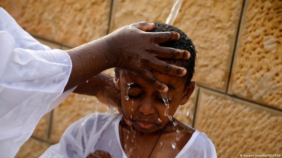 A boy receiving the sign of the cross during a baptism ceremony at the Jordan River, near Jericho in the Israeli-occupied West Bank, 18 January 2020 (photo: REUTERS/Raneen Sawafta)  