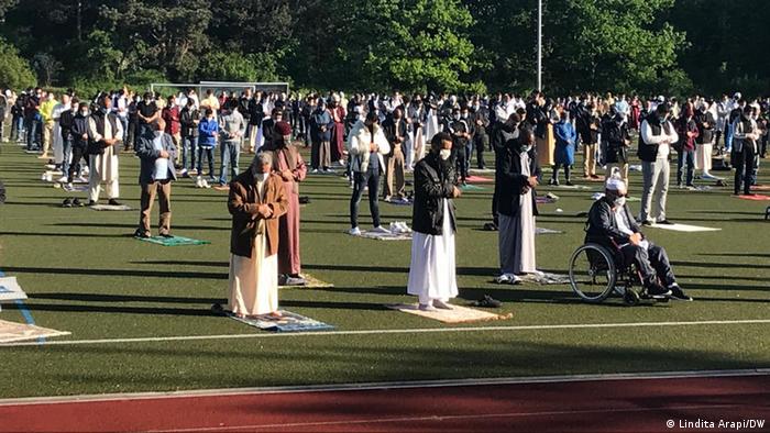 Muslims pray on a sports field in Bonn while keeping their distance and wearing masks