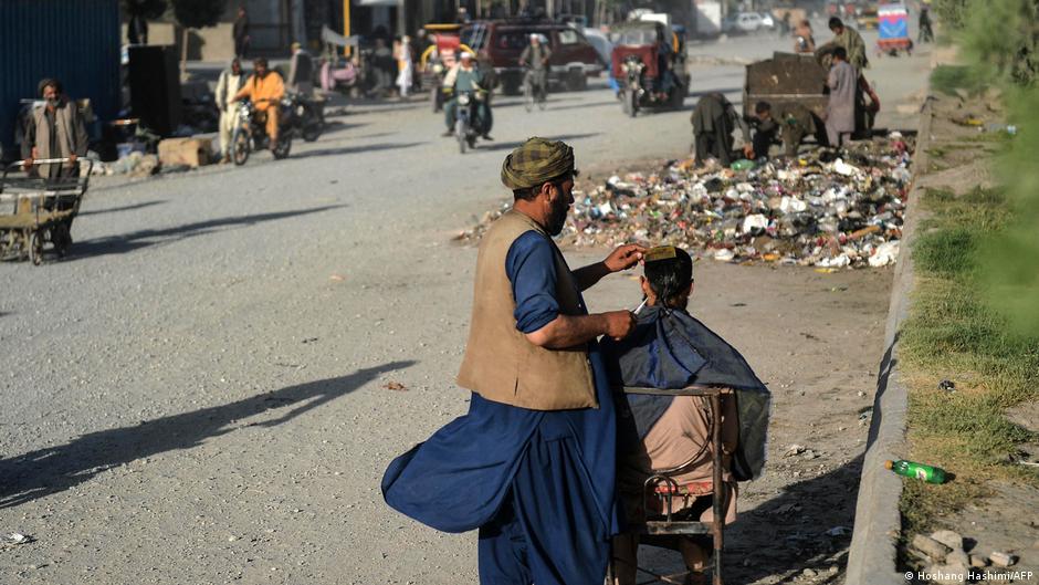 Auf diesem Foto vom 9. Juni 2021 schneidet ein Friseur die Haare eines Kunden an einer Straße in Herat: Foto: Hoshang Hashimi/AFP