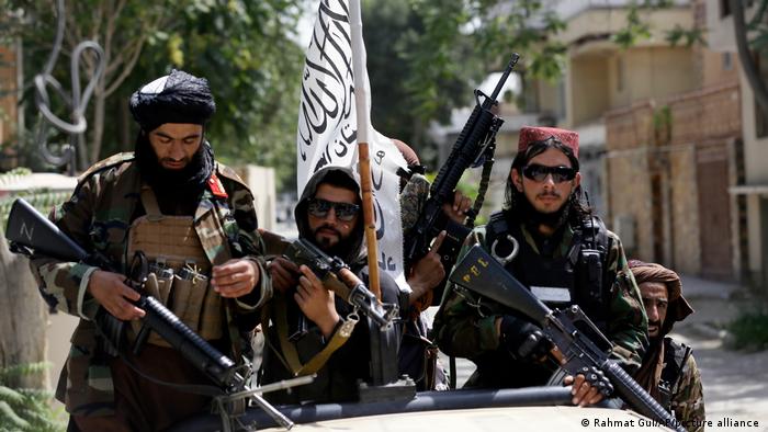 Taliban fighters with guns and their flag in Kabul