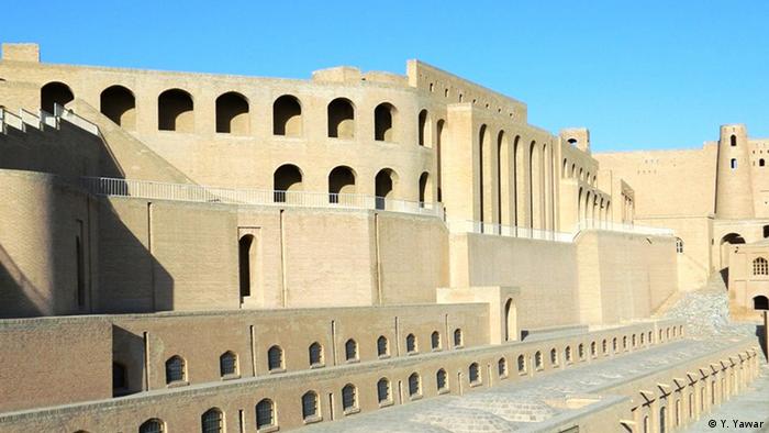 View of sand-coloured large multi-storied building with openings in its facade