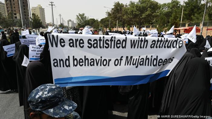 Veiled women hold banners and placards while marching during a pro-Taliban rally outside the Shaheed Rabbani Education University in Kabul on 11 September 2021