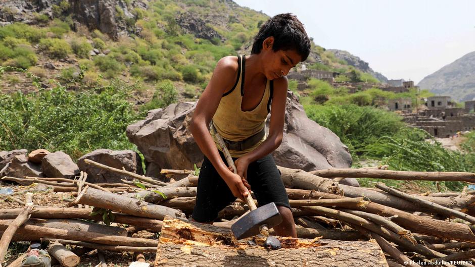 A nephew of lumberjack Ali al-Emadi splits a log with a sledge hammer at his village in Khamis Banisaad district of al-Mahweet province, Yemen, 10 June 2021 (photo: Reuters/Khaled Abdullah)