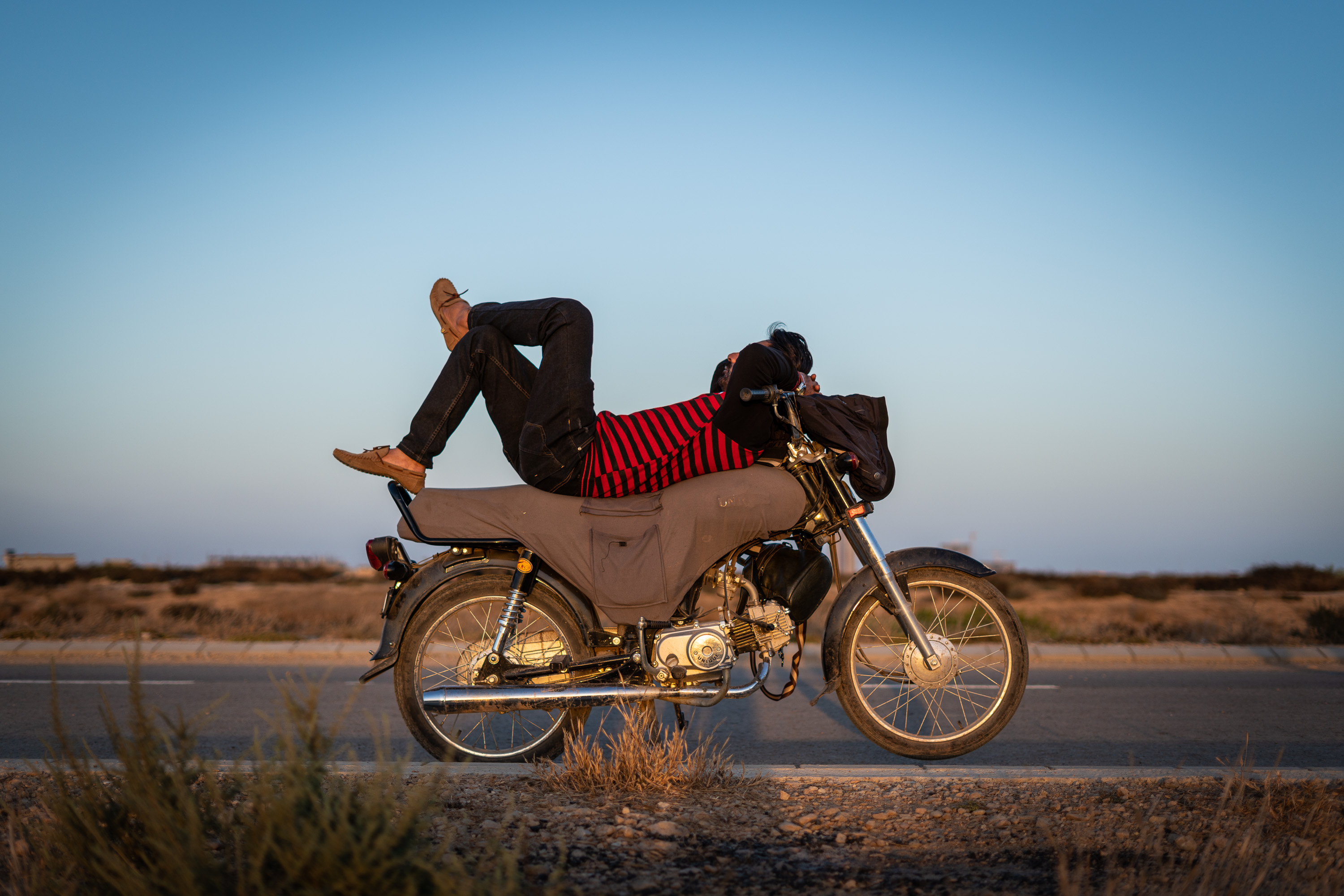 One of the Pink Riders driving instructors takes a break on his bike in Karachi, Pakistan (photo: Philipp Breu)