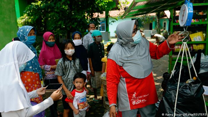 Reden weighs the plastic rubbish she has collected from the children