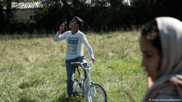 Samiullah Khan Zadran, 13, blows a dandelion clock in the family's garden