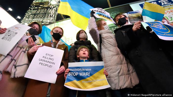 A group of Ukrainian protesters in Tokyo holding up placards