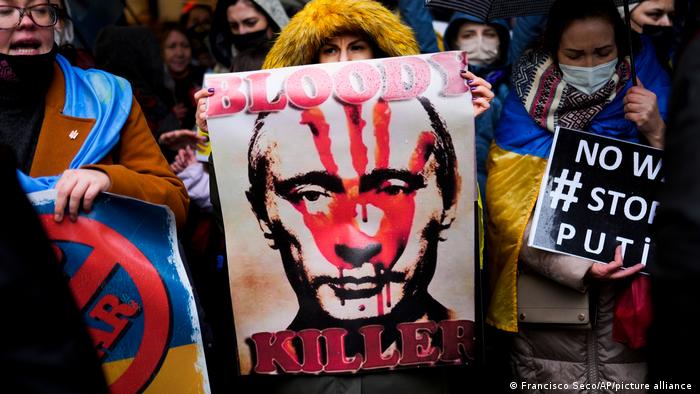 Protesters in Istanbul holding up anti-Putin signs