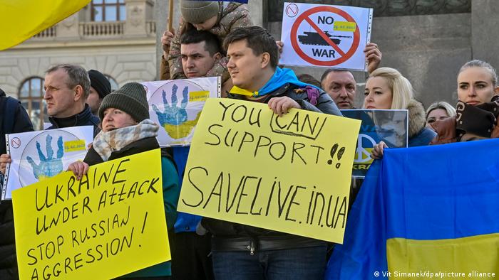 Protesters in Prague holding up anti-war signs