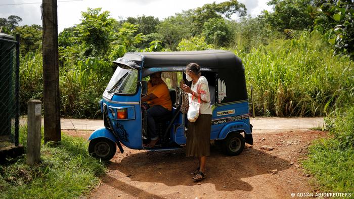 Lasanda Deepthi, talks to a passer-by by the roadside (photo: REUTERS/Adnan Abidi)