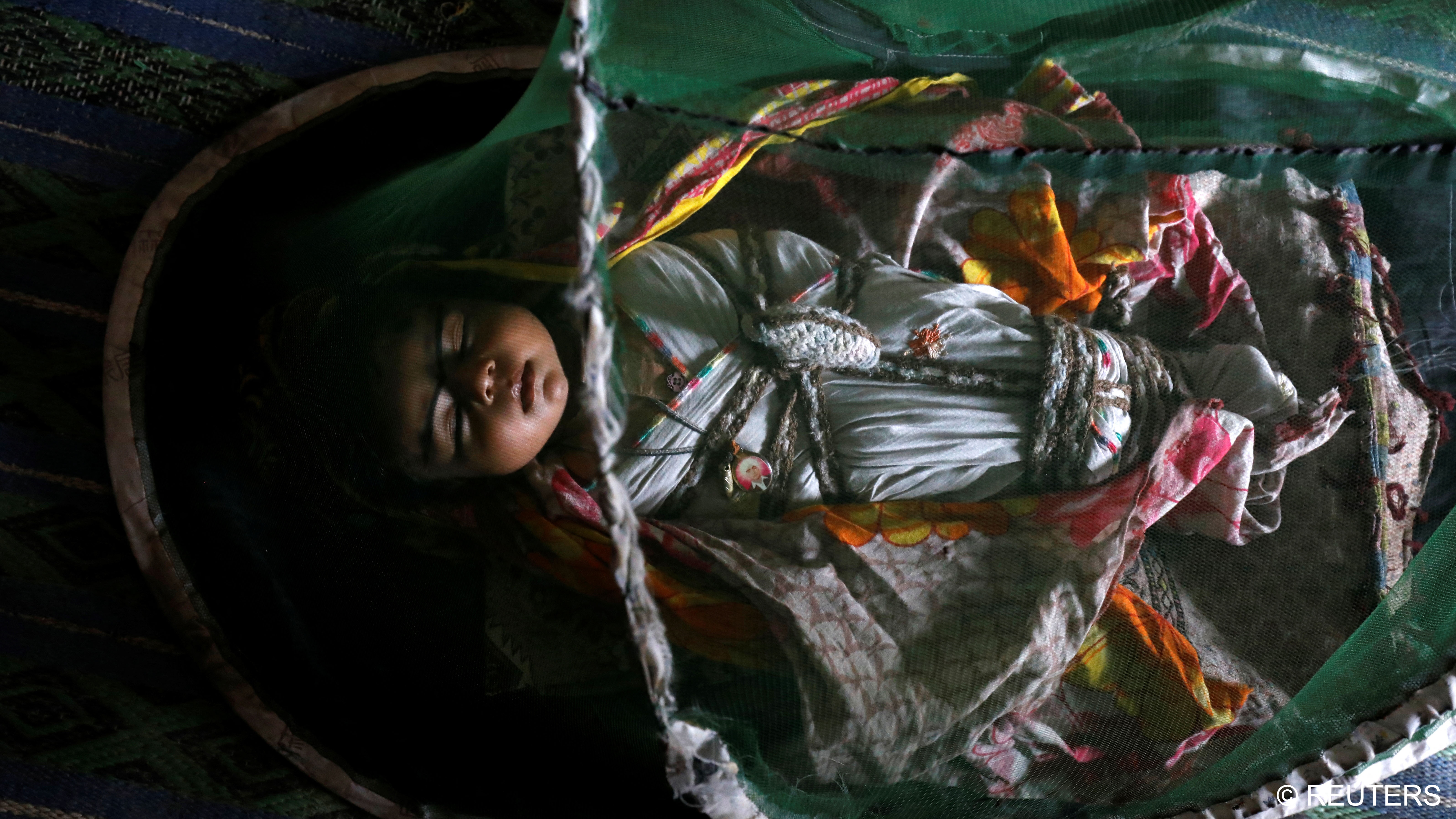 One-month-old Vamar Kumar, sleeps at home under a mosquito net (photo: Reuters/Akhtar Soomro)