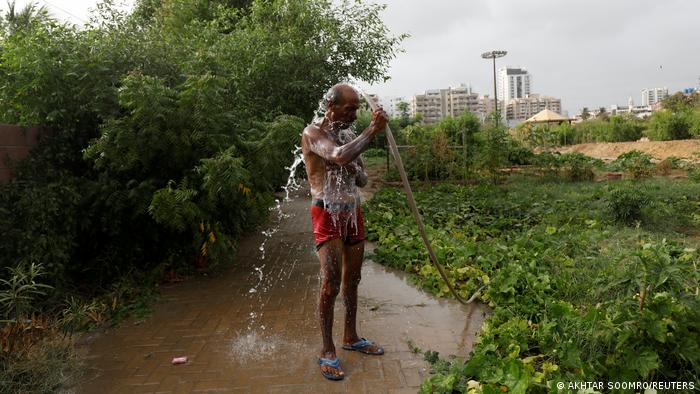 Mulazim Hussain spitzt sich mit einem Wasserschlauch ab; Foto: Reuters