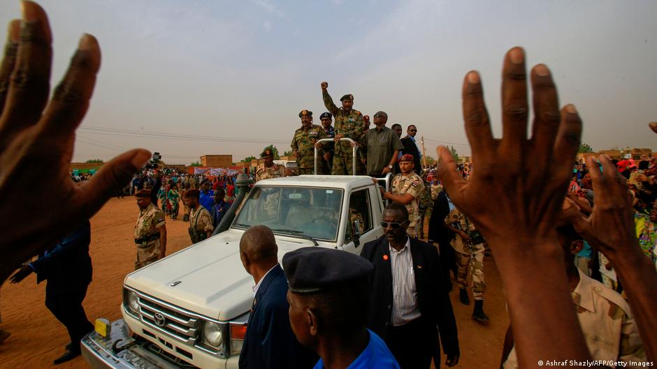 General Abdel Fattah al-Burhan raises a fist surrounded by his supporters (photo: AFP/Getty Images)