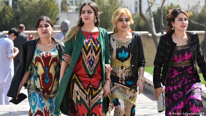 Four young cheerful women in colourful traditional dresses in the sunshine.