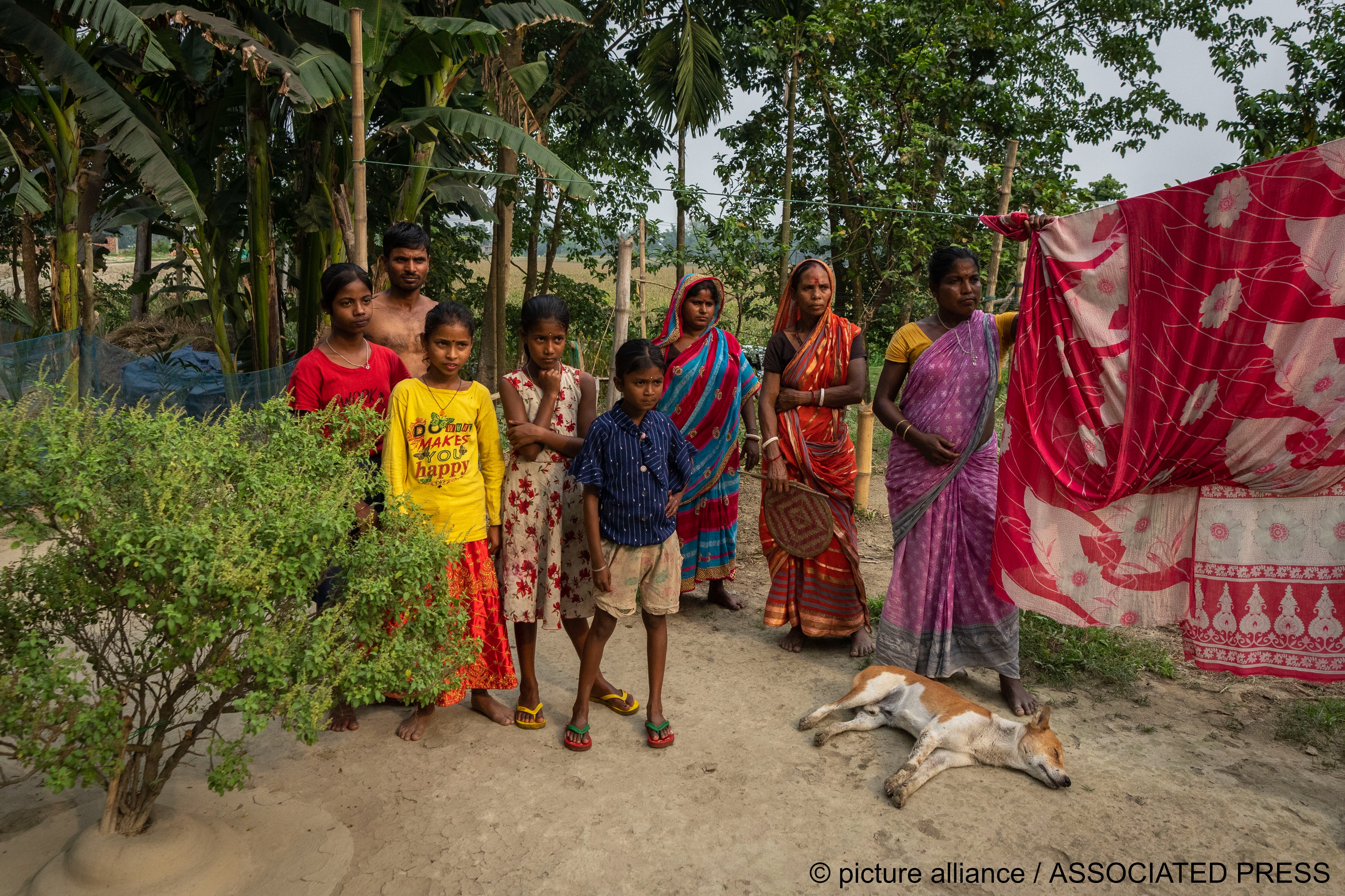 Members of the Biswas family, the majority of whom have not been able to prove their Indian citizenship, look on as their relatives talk to the Associated Press in Murkata village, north eastern Assam state, India, 15 April 2023 (image: AP Photo/Anupam Nath)