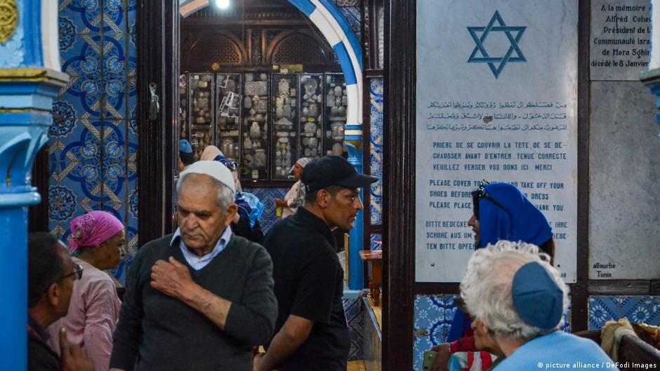 حجاج يهود يشعلون الشموع في كنيس الغريبة بجزيرة جربة التونسية. Jewish pilgrims light candles in El Ghriba synagogue on the Tunisian island of Djerba (image: picture alliance / DeFodi Images)