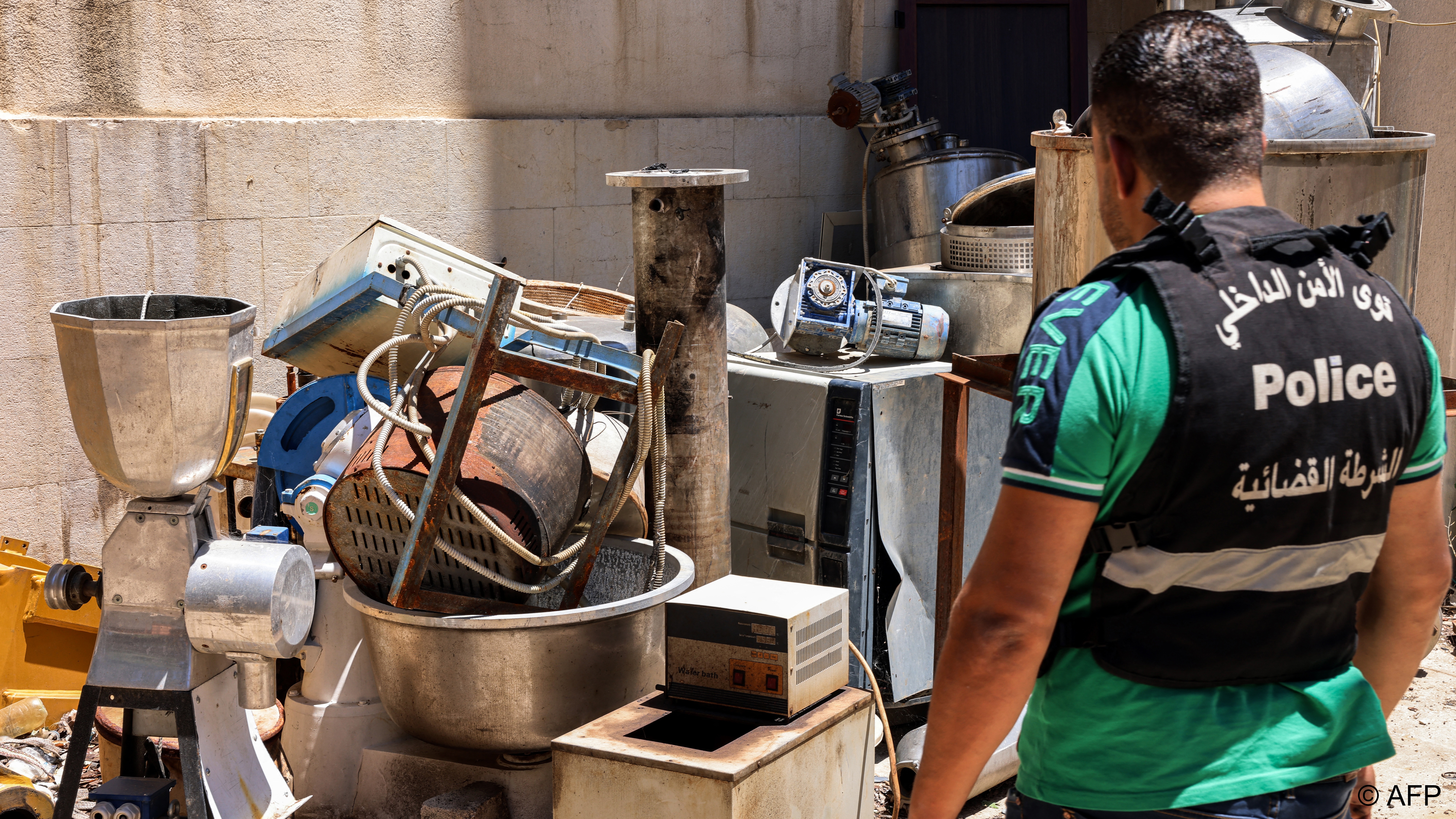 A Lebanese police officer inspects equipment seized from a captagon lab in the Bekaa Valley in July 2022 (image: JOSEPH EID AFP)