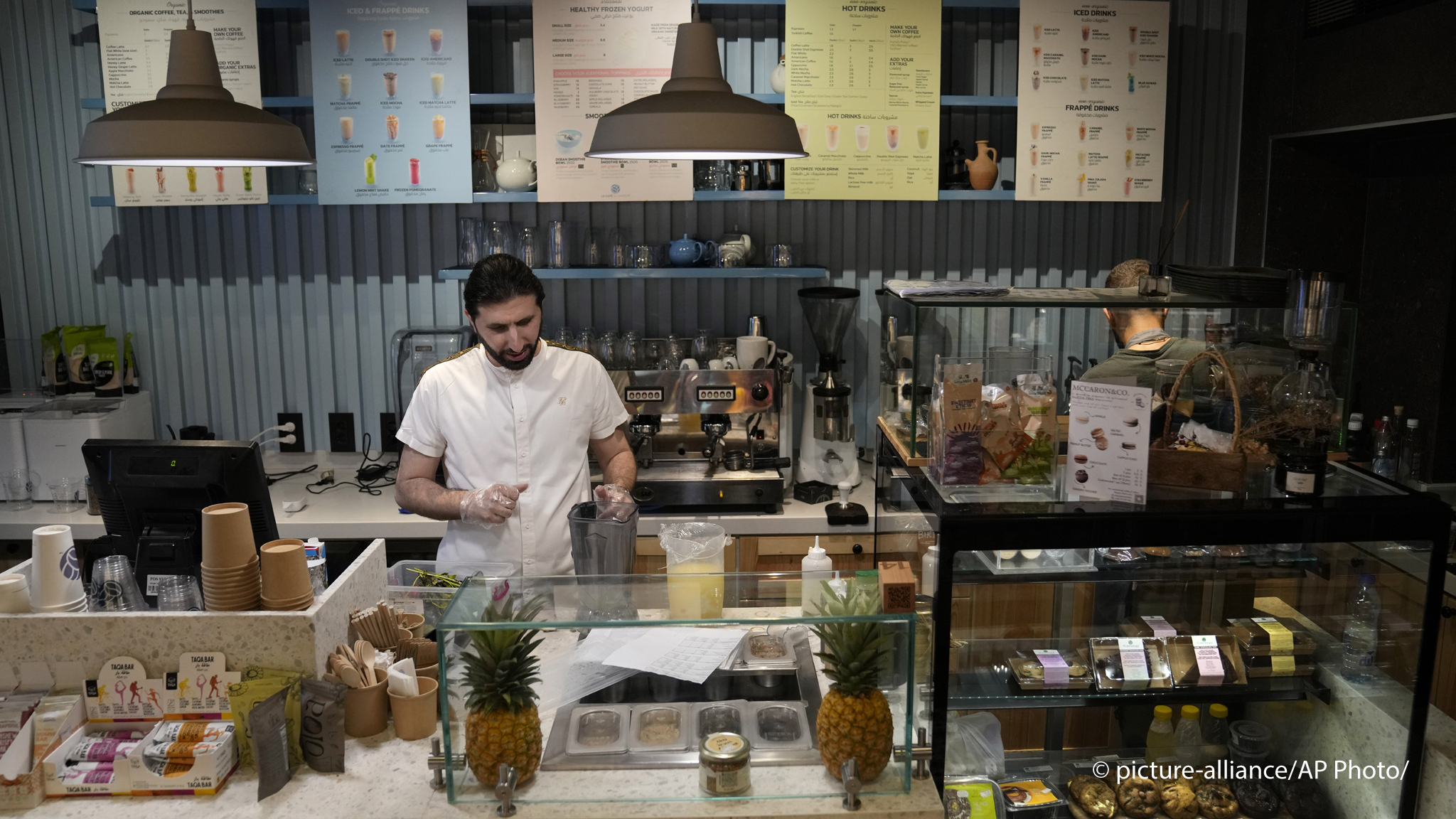 Abbas Bazzi prepares drinks at Le Marché Bio, the organic cafe and grocery store he co-owns, in Beirut, Lebanon, Tuesday, May 30, 2023. Bazzi, who grew up in a secular family but was interested in Islam from an early age, hopes to travel to the Muslim holy city of Mecca, Saudi Arabia, for his fourth Hajj pilgrimage this month (image: AP Photo/Hussein Malla)