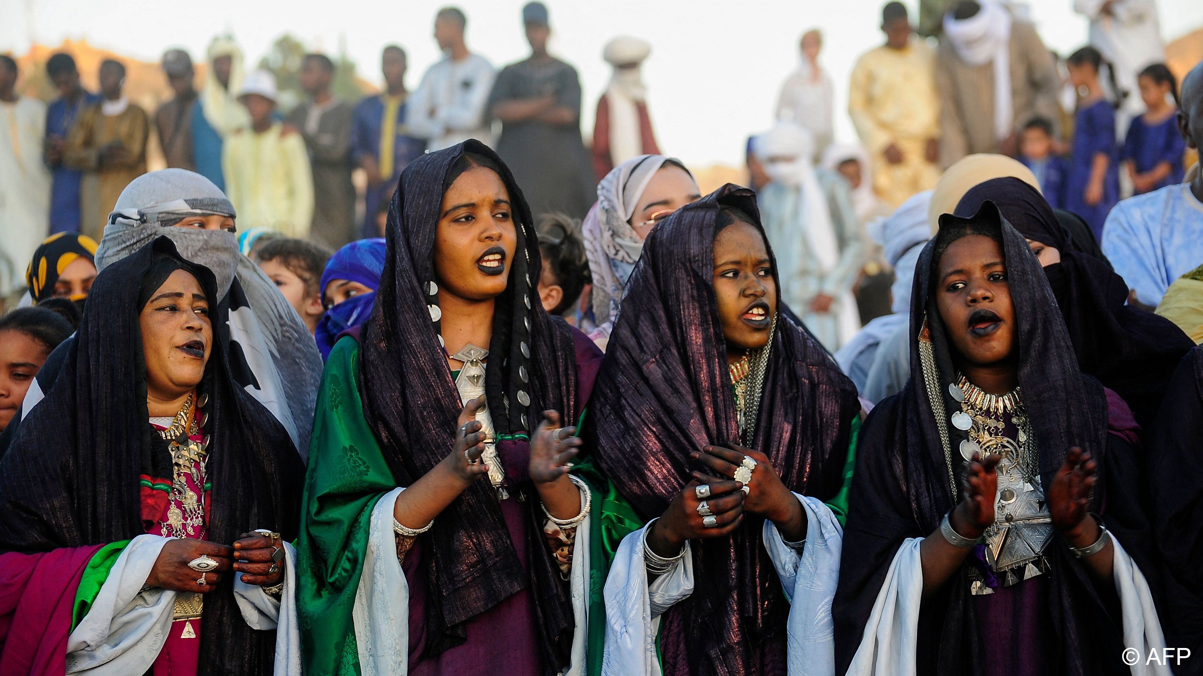 Women sing and beat the tambourine, adorned with glittering jewellery and henna tattoos (image: AFP)