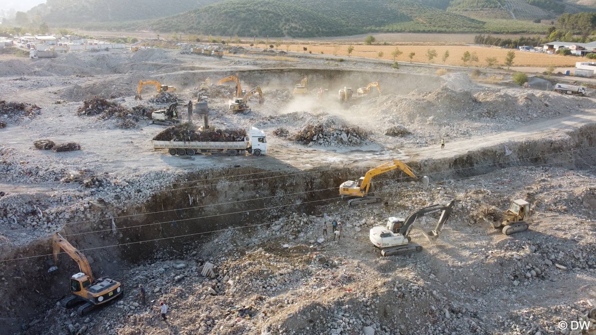 Dust fills the air above a site where excavators work, Hatay, Turkey (image: DW)