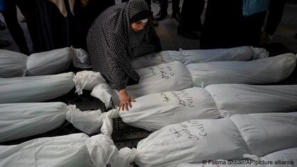 Palestinians mourn their relatives killed in the Israeli bombardment of the Gaza Strip, outside a morgue in Rafah