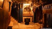 A woman kneels on a marble floor in front of a shrine said to mark the spot where Jesus was born