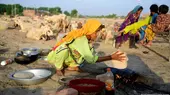 A young Pakistani woman kneels while making bread